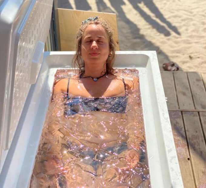 Kobieta leżąca w wodzie z lodem w wannie